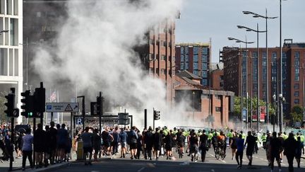 De la fumée s'élève, alors que les policiers affrontent les manifestants, à Liverpool (Royaume-Uni), le 3 août 2024 (PETER POWELL / AFP)