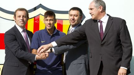 Neymar lors de son arrivée au FC Barcelone, entouré du président de l'époque,&nbsp;Sandro Rosell, du directeur et futur président, Josep Maria Bartomeu, ainsi que d'Andoni Zubizarreta, en juin 2013. (ALBERT SALAMZ / ANADOLU AGENCY / AFP)