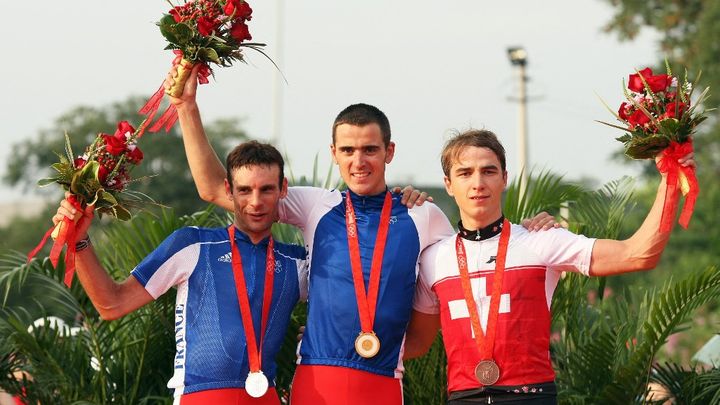 Julien Absalon et sa deuxième médaille d'or à Pékin le 23 août 2008, aux côtés d'un autre VTTiste français, Jean-Christophe Peraud pour l'argent, à gauche, et du Suisse  Nino Schurter, médaillé de bronze. (CARL DE SOUZA / AFP)