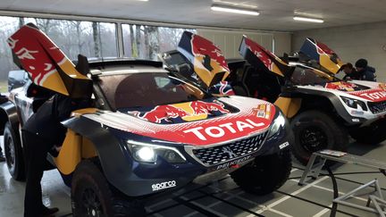 Sur un circuit privé de PSA, à la Ferté-Vidame, en Normandie, les deux voitures 3008 DKR Maxi numéro 306 de Sébastien Loeb et 303 de l’Espagnol Carlos Sainz sont examinées par les ingénieurs et les mécaniciens. (GUILLAUME BATTIN / RADIOFRANCE)