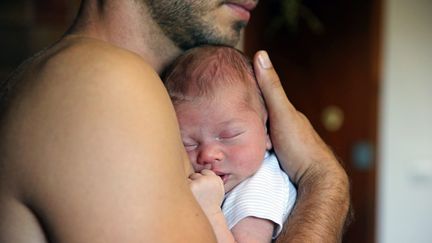 Un bébé dans les bras de son père. (VANESSA MEYER / MAXPPP)