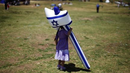 Une petite Isra&eacute;lienne joue avec un marteau gonflable aux couleurs de son pays pour c&eacute;l&eacute;brer l'anniversaire de l'ind&eacute;pendance d'Isra&euml;l &agrave; J&eacute;rusalem (Isra&euml;l), le 26 avril 2012. (AMIR COHEN / REUTERS)