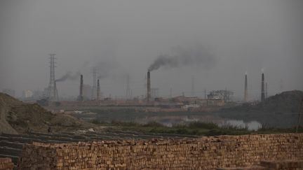 De la fumée s'échappe de cheminées d'un site de fabrication de briques alimenté au charbon, le 19 février 2020, à Dhaka (Bangladesh) (AHMED SALAHUDDIN / NURPHOTO / AFP)