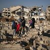 Une famille se tient devant des tombes détruites, dans un cimetière de Jobar (Syrie), le 18 décembre 2024. (ARIS MESSINIS / AFP)