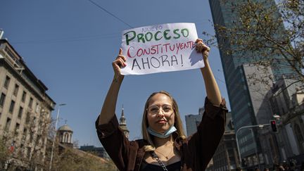 Une étudiante manifeste à Santiago, le 14 septembre 2022. Sur sa pancarte : "Un nouveau processus constitutionnel maintenant !" (MARTIN BERNETTI / AFP)