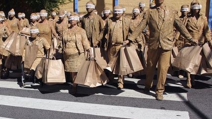 Des &eacute;tudiants en arts r&eacute;alisent une performance afin de d&eacute;noncer la soci&eacute;t&eacute; de consommation, devant un centre commercial &agrave; Natal (Br&eacute;sil), le 9 d&eacute;cembre 2013. (REUTERS)