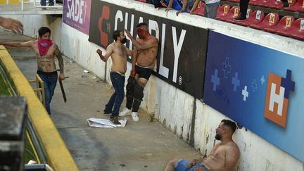 Des supporters d'Atlas se battent avec des supporters de Queretaro lors du match de football du tournoi de clôture mexicain entre Queretaro et Atlas au stade Corregidora de Queretaro, au Mexique, le 5 mars 2022. (STR / AFP)