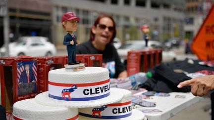 Une vendeuse propose&nbsp;une poupée à l’effigie de Donald Trump, le 17 juillet 2016 à Cleveland (Etats-Unis), à la veille de l’ouverture de la convention républicaine. (JEFF J MITCHELL / GETTY IMAGES NORTH AMERICA / AFP)