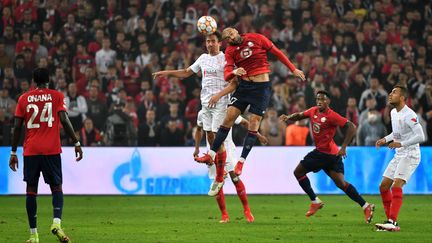 Le Turc du Losc&nbsp;Burak Yilmaz au duel aérien avec le défenseur espagnol de Seville, Sergio Escudero, lors du match Lille-Seville mercredi 20 octobre 2021. (DENIS CHARLET / AFP)