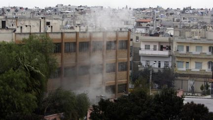 De la fum&eacute;e s'&eacute;chappe depuis un b&acirc;timent de la ville de Homs le 11 janvier 2012, apr&egrave;s une attaque &agrave; la roquette. (JOSEPH EID / AFP)