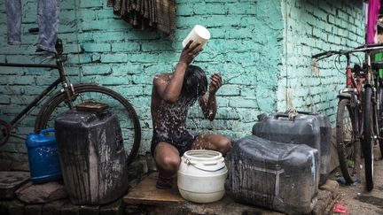 Un jeune homme se rafraîchit durant la canicule à New Dehli (Inde), le 3 mai 2022. (XAVIER GALIANA / AFP)