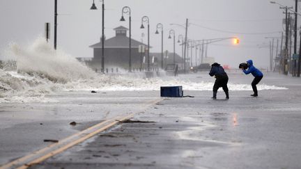 Malgr&eacute; les recommendations des autorit&eacute;s, certains habitants se sont risqu&eacute;s dehors pour photographier l'&eacute;v&egrave;nement, comme ici &agrave; Cape May dans le New Jersey, point d'entr&eacute;e de Sandy sur la c&ocirc;te.&nbsp; (MEL EVANS AP / SIPA)