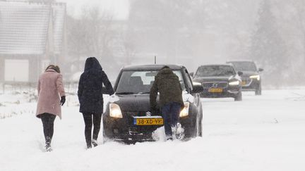 Des gens poussent leurs voitures dans la neige, le 7 février 2021, à Haarlem (Pays-Bas). (VINCENT JANNINK / ANP)