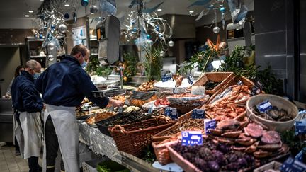 Des salariés d'une poissonnerie organise les étals de poisson, à Paris, en décembre 2020. (STEPHANE DE SAKUTIN / AFP)