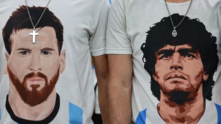 Des supporters argentins portent des t-shirts à l'effigie de Lionel Messi et Diego Maradona lors de la demi-finale de la Coupe du monde 2022 au Qatar. (GIUSEPPE CACACE / AFP)