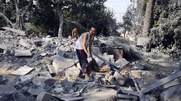 Un Palestinien dans les d&eacute;combres d'une maison de Chajaya en banlieue de Gaza, le 20 juillet 2014. ( IBRAHEEM ABU MUSTAFA / REUTERS)