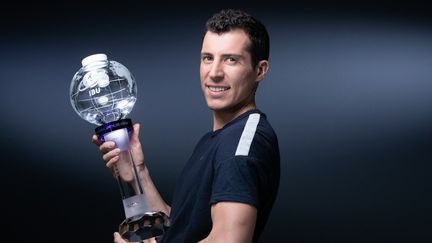 Quentin Fillon Maillet pose avec son globe de cristal, le trophée pour sa victoire finale au classement général de la Coupe du monde 2021-2022. (JOEL SAGET / AFP)