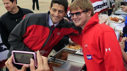 J-22 #TEAMROMNEY Le candidat r&eacute;publicain &agrave; la vice-pr&eacute;sidence am&eacute;ricaine, Paul Ryan&nbsp;(C), pose avec un b&eacute;n&eacute;vole en marge d'un meeting &agrave; Cincinnati (Ohio), le 15 octobre 2012. (AL BEHRMAN / AP / SIPA)