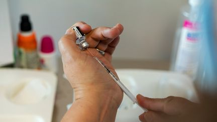 Un soignant prépare une dose de rappel de vaccin contre la grippe et le Covid-19 à l'hôpital Saint-Camille de Bry-sur-Marne (Val-de-Marne), le 18 novembre 2021. (ALINE MORCILLO / HANS LUCAS / AFP)