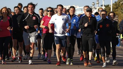 Le maire UMP&nbsp;sortant de Nice (Alpes-Maritimes), candidat &agrave; sa propre succession, Christian Estrosi (au centre), fait son jogging avec ses partisans, le 8 mars 2014. ( ERIC GAILLARD / REUTERS)