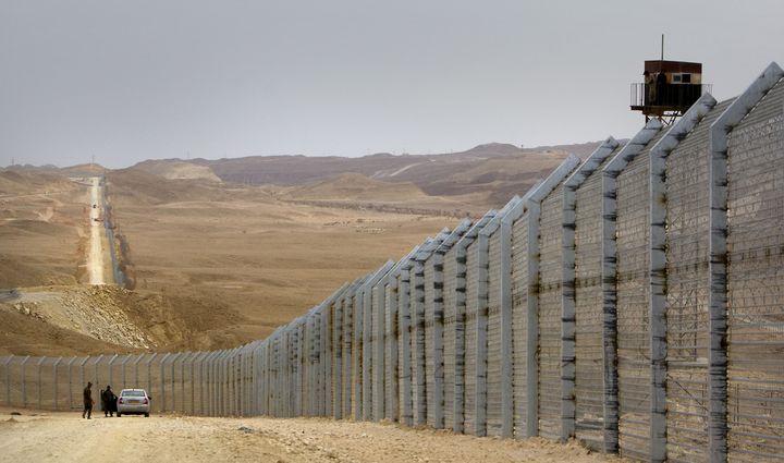 Des gardes-fronti&egrave;res isra&eacute;liens supervisent la construction de la barri&egrave;re m&eacute;tallique dans le Sina&iuml;, &agrave; la fronti&egrave;re avec l'Egypte, le 15 f&eacute;vrier 2012.&nbsp; (AHMAD GHARABLI / AFP)