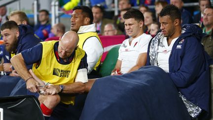 ANGLETERRE-PAYS DE GALLES. Ben Youngs grimace de douleur alors qu'un médecin de l'équipe s'occupe de sa cheville droite, le 26 septembre 2015. (ANDREW WINNING / REUTERS)