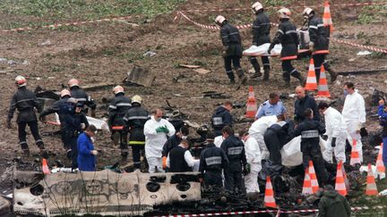 Des pompiers et des sauveteurs &eacute;vacuent les corps des victimes du Concorde qui s'est &eacute;cras&eacute; le 26 juillet 2000, &agrave; Gonesse (Val-d'Oise).&nbsp; (JACK GUEZ / AFP)