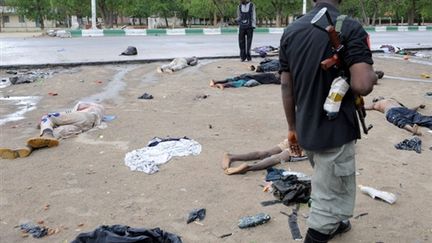 Un policier regarde les cadavres d'islamistes morts durant les combats le 28 juillet 2009 (© AFP Pius Utomi Ekpei)