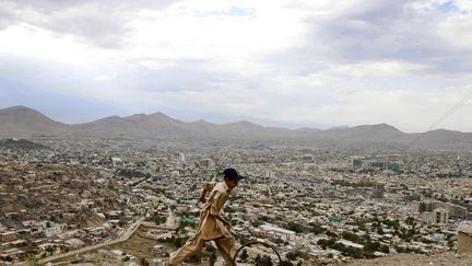 Un jeune afghan joue avec une cerceau sur une colline &agrave; Kaboul (Afghanistan), le 19 juin 2012. (AHMAD JAMSHID / AP / SIPA)