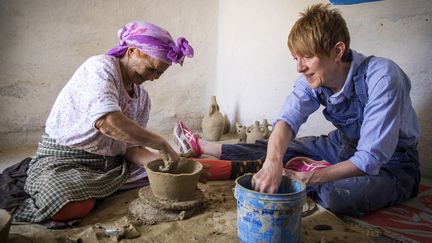 La potière marocaine Aicha Tabiz assise à côté de l'apprentie britannique Kim West, 33 ans, lors d'un atelier de poterie près du village d'Ourtzagh, au pied des montagnes du Rif, le 12 juin 2019.&nbsp; (FADEL SENNA / AFP)