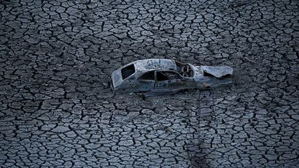 Une carcasse de voiture g&icirc;t dans le lac artificiel &agrave; sec d'Almaden Reservoir &agrave; San Jose en raison de la grande s&eacute;cheresse qui touche la Californie (Etats-Unis), le 28 janvier 2014. (JUSTIN SULLIVAN / GETTY IMAGES / AFP)