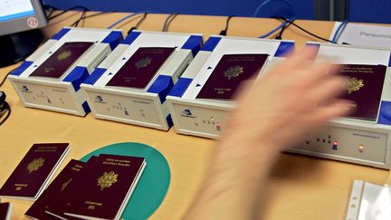 Un employ&eacute; de l'Imprimerie nationale de Flers-en-Escrebieux, pr&egrave;s de Douai (Nord), positionne des passeports pour activer les puces &eacute;lectroniques, le 12 avril 2006. (PHILIPPE HUGUEN / AFP)