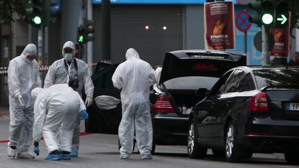 La police inspecte la voiture de l'ancien Premier ministre grec Lucas Papademos, blessé par une explosion, le 25 mai 2017 à Athènes. (ANGELOS TZORTZINIS / AFP)