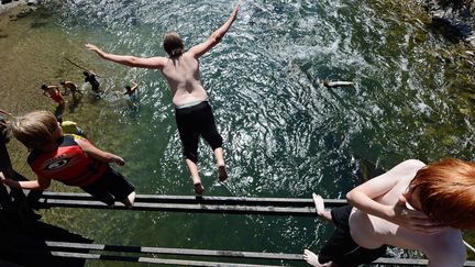 Sun Valley (Idaho), 32 &deg;C, le 9 juillet 2012. Des adolescents plongent dans une rivi&egrave;re depuis une voie ferr&eacute;e abandonn&eacute;e. (KEVORK DJANSEZIAN / GETTY IMAGES)