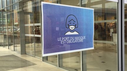 Une affiche à l'entrée d'un centre-commercial de Thoiry dans l'Ain. Photo d'illustration. (STÉPHANE MILHOMME / FRANCE-INFO)