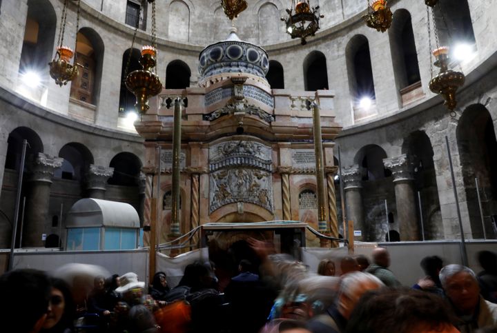 Des visiteurs photographient l'édicule restauré, le 20 mars 2017, en l'église Saint-Sépulcre de Jérusalem (Israël). (RONEN ZVULUN / REUTERS)