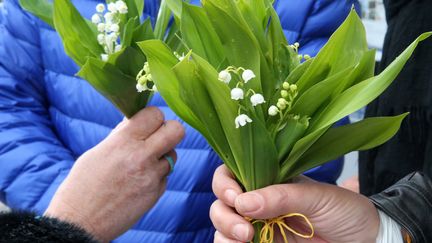 Deux personnes tiennent des brins de muguet, le 1er mai 2016, à Saint-Gervais-les-Bains (Haute-Savoie). (LEEMAGE / AFP)