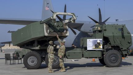 Des soldats américains inspectent un système de roquettes d'artillerie de type Himars au salon aéronautique international de Bahreïn, à Sakhir, le 13 novembre 2024. (MAZEN MAHDI / AFP)