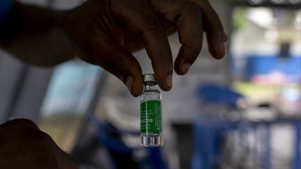 Un médecin présente un flacon du vaccin Oxford/AstraZeneca Covid-19 au centre de santé Vijana à Kinshasa, le 19 mai 2021. (ARSENE MPIANA / AFP)