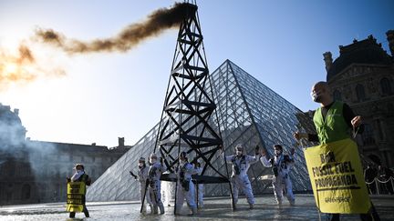 Une vingtaine d'activistes de Greenpeace ont manifesté devant le Louvre à Paris pour&nbsp;protester contre le partenariat entre le musée et TotalEnergies, le 6 octobre 2021.&nbsp; (ANNE-CHRISTINE POUJOULAT / AFP)