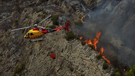 Un hélicoptère des pompiers survole un incendie, en Catalogne, jeudi 16 juin 2022.&nbsp; (PAU BARRENA / AFP)