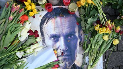 Des fleurs sont placées autour d’un portrait du chef de l’opposition russe Alexei Navalny lors d’un mémorial improvisé à Francfort-sur-le-Main, en Allemagne de l’Ouest, le 29 février 2024. (- / AFP)