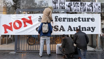 Des salari&eacute;s de PSA installent une banderole lors d'une manifestation devant des locaux du groupe, &agrave; Paris, le 25 octobre 2012. (FRANCOIS GUILLOT / AFP)