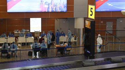 Des médecins russes portent des tenues de protection pour examiner les passagers à l'aéroport international de Moscou (Russie), le 26 mars 2020. (GRIGORY SYSOEV / SPUTNIK / AFP)