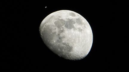 La Lune et la station spatiale internationale, photographi&eacute;es depuis Houston (Texas), le 4 janvier 2012. (LAUREN HARTNETT / NASA / AFP)