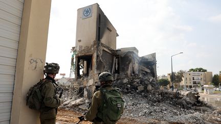 Soldiers stand in front of an Israeli police station in Sderot, damaged during fighting to dislodge Hamas militants stationed there, October 8, 2023. (JACK GUEZ / AFP)