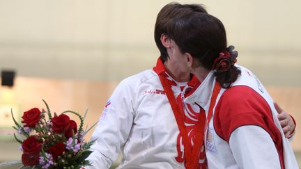 La Russe Natalia Paderina (à gauche) et la Géorgienne Nino Salukvadze s'embrassent sur le podium, le 10 août 2008, lors des Jeux de Pékin, en Chine. (MICHAEL REYNOLDS / EPA / AFP)