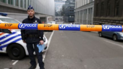 Un policier devant le siège de la police fédérale belge, à Bruxelles, où est entendu Salah Abdeslam, le 19 mars 2016.&nbsp; (FRANCOIS LENOIR / REUTERS)