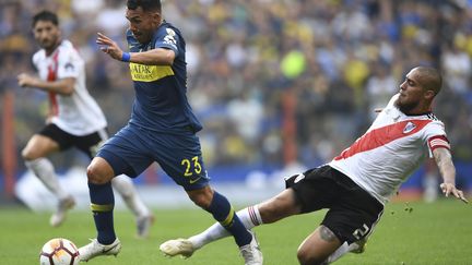 Un joueur de Boca Junior (à g.) se fait tacler par un joueur de River Plate, lors du match aller de la finale de la Copa Libertadores, le 11 novembre 2018. (EITAN ABRAMOVICH / AFP)