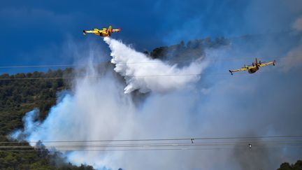 Deux Canadair larguent de l'eau dans les environs de Mirabeau (Vaucluse), le 24 juillet 2017. (BERTRAND LANGLOIS / AFP)